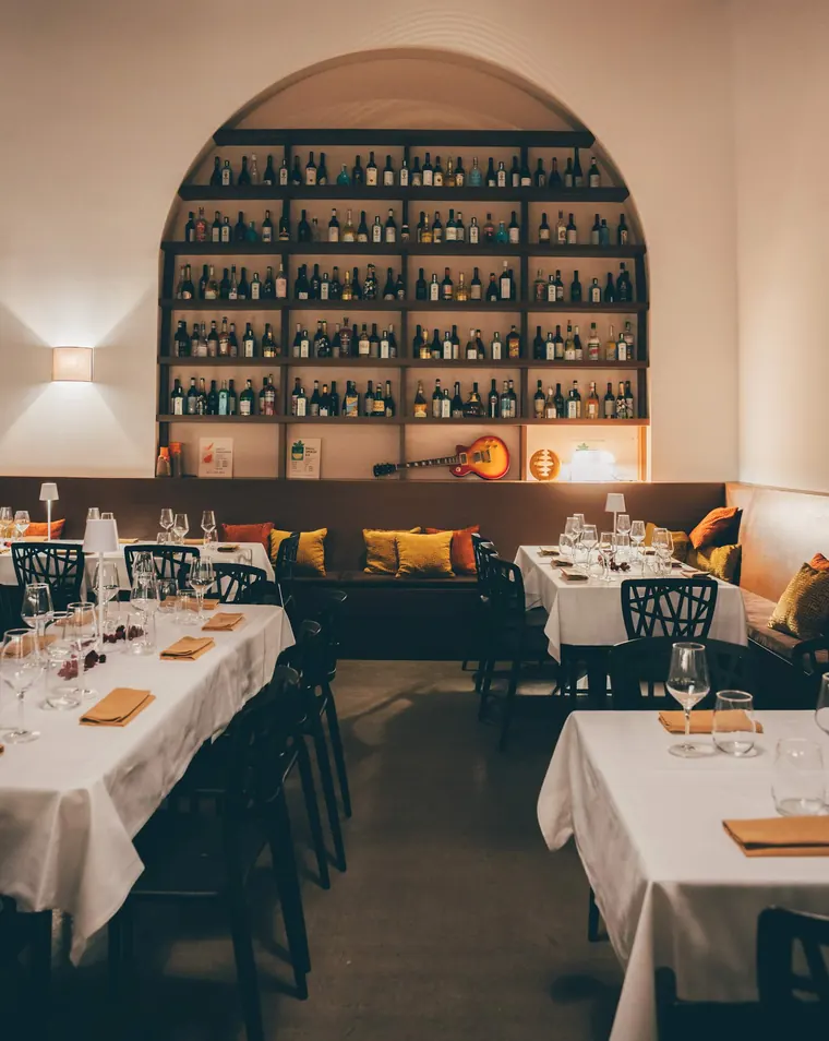 La panca con i cuscini gialli e rossi e i tavoli della sala