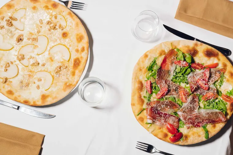 Due pizze viste dall'alto sul tavolo apparecchiato